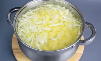 В бульон с мясом говядины отправить картошку, капусту и дать закипеть.