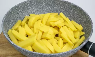 Выложить в сковороду картофель в разогретое растительное масло.